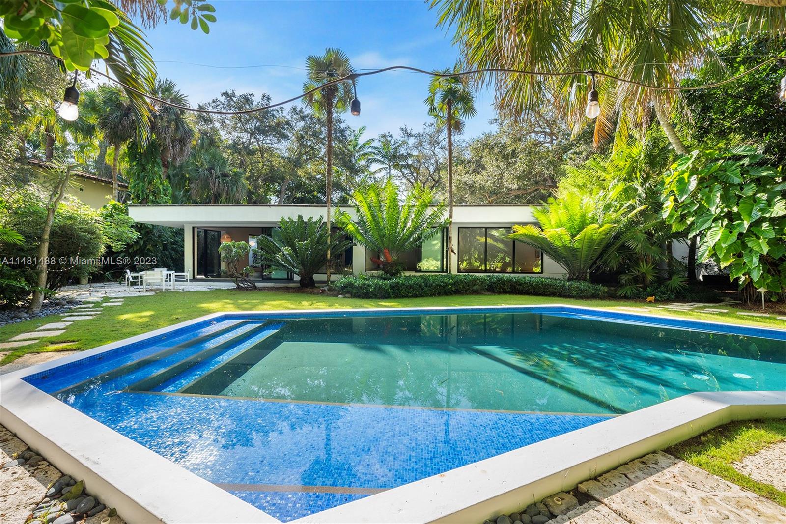 Classic Modern masterpiece designed by renowned minimalist architect Jorge Arango, offers timeless construction, style and quality, located on one of the most coveted lanes in all of Coconut Grove. Walled and enclosed with a courtyard entry, this tropical paradise presents open flow living spaces, Corbusier inspired kitchen, 3 spacious bedrooms + a large den office, slate floors, Bisazza tiles in the bathrooms. Walls of impact glass doors open to covered terraces surrounding the home and gardens. Landscape by Raymond Jungles features magnificent specimen palms, living walls and rare tropical foliage. A showpiece angular swimming pool with tiled steps and water seating benches compliment a secluded egg-shaped spa and outdoor shower + an elevated garden terrace. 2-c carport, storage room.