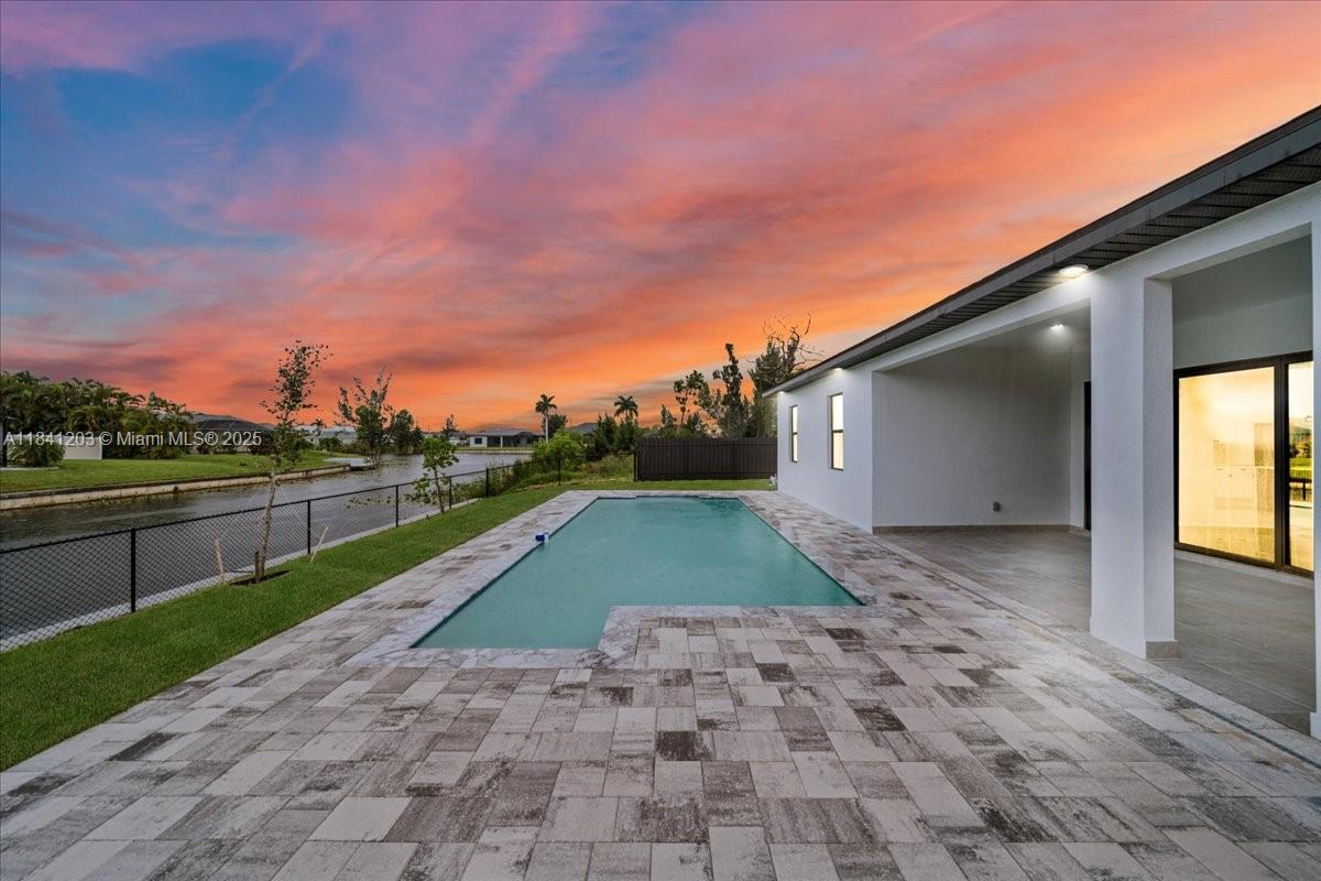 New construction with 4 bedrooms and 3 bathrooms. With nearly 1,900 square feet of living space and nearly 3,000 square feet under roof, this residence boasts soaring 12-13 foot coffered ceilings, elegant porcelain tile throughout, and a spacious open-concept layout. The fully equipped kitchen features high-end finishes and ample countertop space for the passionate cook or host. Retreat to the luxurious master suite, featuring a sleek, modern bathroom with a double vanity and dual rain shower. Step outside to your own private retreat: a beautifully designed concrete pool, an outdoor summer kitchen, and tranquil views of a freshwater canal. Featuring a two-car garage, curb appeal, and exceptional attention to detail, this home boasts a spacious living room with ample closet space!