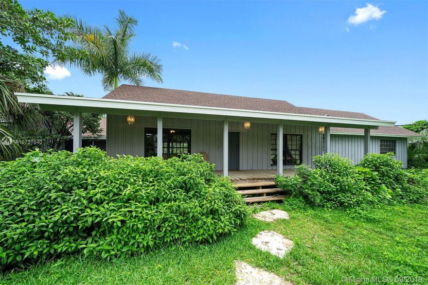 Rare opportunity to own a piece of South Florida History with this 4 bdrm/ 3.5 bath + office, Florida Cracker style home fashioned after the late author Marjorie Kinnan Rawlings famous home. Built entirely out of Red Cedar in 1978 to mirror old Florida by capturing all the natural light and breezes that South Florida has to offer. Wrap around porches, vaulted 20-foot ceilings in the family room with exquisite Pecky Cypress paneling. American chestnut walls in the office and den area. Utility room. 1 car covered carport, attached workshop. All rooms look out over private pool and patio on wooded and secluded 5 acres including mature tropical hardwoods. Detached 3 stall pole barn and shed.