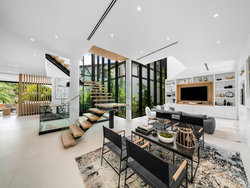 Embrace the ultimate luxury lifestyle in Coconut Grove, where tropical scenery & natural finishes define this contemporary waterfront oasis. Recently redesigned, this residence offers 5 bedrooms, 5 full & 1 half baths, 3 balconies and expansive terraces for seamless indoor-outdoor living. Walls of glass capture sweeping bay vistas, while dual pools & a private dock with direct ocean entry set the stage for premier waterfront living. Inside, discover a chef’s kitchen, glass-enclosed lounge & dining areas, plus a striking primary suite with panoramic water views, spa-inspired bath & full sauna. With innovative design, organic details & expansive spaces, this estate delivers elegance & sophistication in one of Miami’s most coveted neighborhoods.