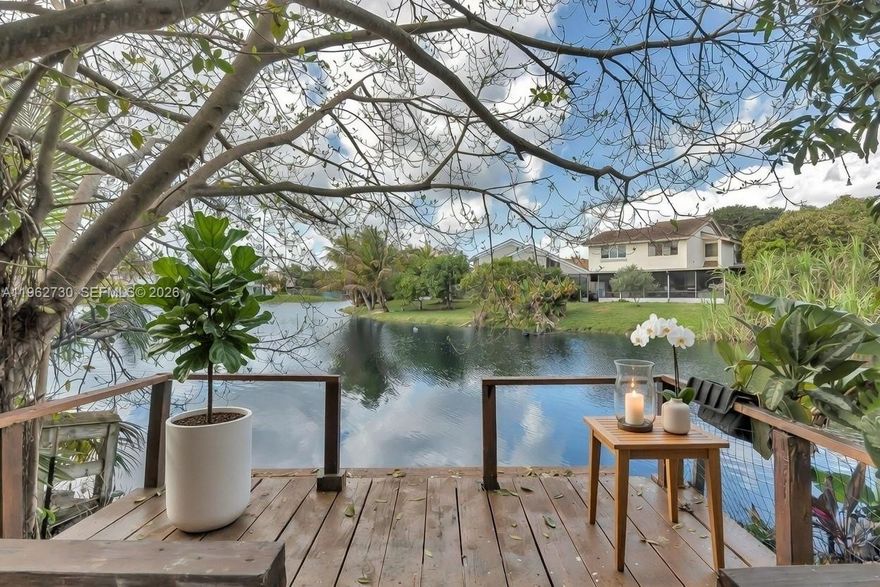 Discover lakeside serenity in this exquisite approximately 2,000-square-foot retreat, boasting your own private dock for effortless waterfront access. Elegantly designed with 3 bedrooms and 3 full bathrooms, including a convenient downstairs bedroom ideal for guests or multigenerational living. Step through the grand entryway graced by soaring high ceilings, inviting natural light and a sense of spacious grandeur. The tranquil backyard oasis offers ultimate privacy, adorned with lush fruit trees that provide seasonal delights. Perfectly positioned within walking distance to a charming playground, this home harmonizes peaceful seclusion with community convenience—truly a haven for refined living.