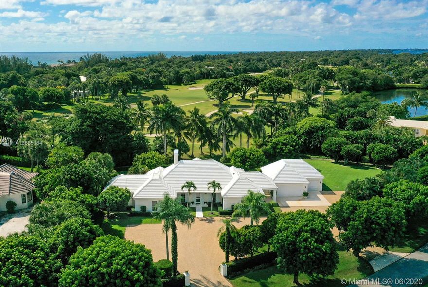 This stately Bermuda-style house is in near perfect condition and offers a beautiful environment for those who love generous spaces and wonderful places to entertain both formally and casually. The 4-bedroom home is nicely situated with a southeastern exposure that present expansive fairway views along with ocean breezes. Step into the entry loggia with hand-crafted built-ins that flank the entrance to spacious great room. Great room houses a formal dining and living area with fireplace. Just beyond, lies a bright, open family room with a wall of glass doors offering view of the pool and patio. Family room also offers a newly added granite topped wet bar. Home features an oversized eat-in kitchen with center island and ample counter space, custom cabinetry and luxury appliances.