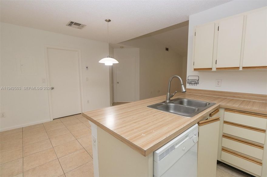 Experience luxury living in this stunning 1-bedroom, 1-bathroom condo located within the secure, family-friendly gated community of La Hacienda. This second-floor residence boasts vaulted ceilings and tile flooring throughout, complemented by modern light fixtures and an open-concept kitchen with newer appliances. For your convenience, the unit includes an in-home washer and dryer and one assigned parking space. Residents enjoy premium amenities including a swimming pool, clubhouse, and gym, all protected by 24/7 security. Perfectly situated for commuters, you'll have rapid access to the 826, I-95, and I-75, and find yourself just minutes away from top-tier shopping, dining, and healthcare.