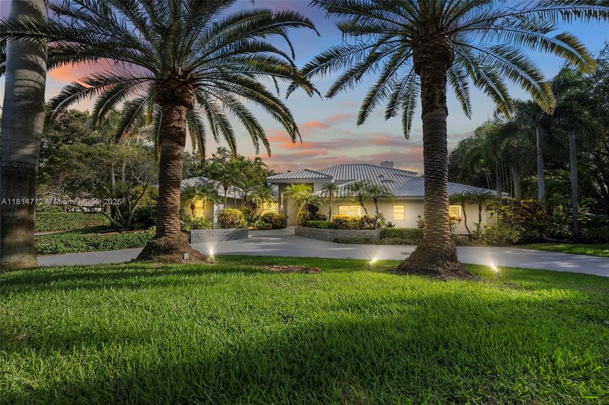 Elegant one-story entertainer’s delight estate with guest house in prestigious Windmill Ranch. Spanning 1.43 landscaped acres, grand circular drive lined by Royal Palms. Marble patio, heated pool, spa, and serene garden views. Inside: 4486 living sqft and 5299 adjusted sqft, 5BD, 4.5BA, marble floors in main areas, wood in bedrooms, floor-to-ceiling fireplace, and cathedral wood-beam ceiling in formal living room. Upgraded chef’s kitchen—massive quartz island, double ovens, wine coolers—opens to sun-lit family and dining room. Separate guest house with full bath offers flexible space for in-laws, office, or playroom. Wood-paneled office, impact glass, accordion shutters, and shaded patio cover complete this rare private indoor-outdoor retreat in one of Weston’s premier communities.