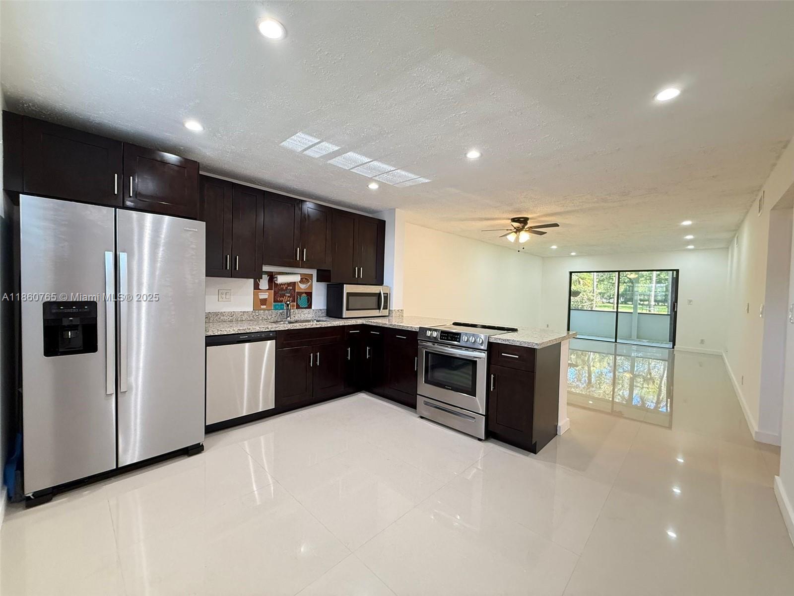 Stunning renovated first-floor apartment with 1,270 sq ft (including Patio). This spacious unit features a modern open kitchen with stainless steel appliances, a stylish bar area, and abundant natural light. Upgrades include A/C (2023), roof(2023), washer and dryer(2023), new refrigerator (2025), garbage disposal (2019), and a new elevator (2025). The apartment offers a large walk-in closet, serene garden views, and convenient parking in front of the unit. Condo fees include basic cable, Internet, water, and sewer. Ideally located 5 minutes from the Turnpike,15 minutes from I-95, 5 minutes from Walmart and Commercial Blvd,and close to shopping plazas,restaurants,and parks.This peaceful community combines comfort, convenience,and modern upgrades—making it the perfect place to call home