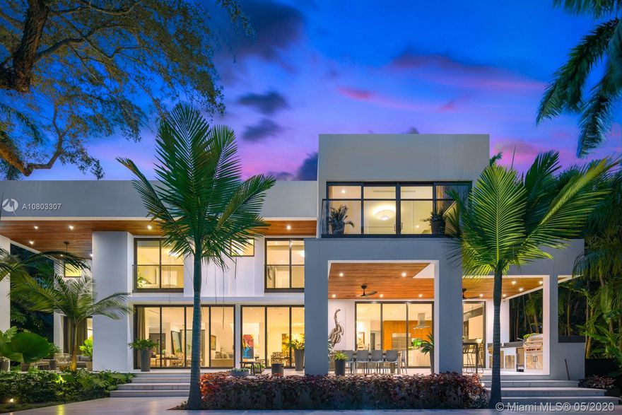 Embrace this 6,784 total sf two-story sustainable modern masterpiece on a 15,912 sf lot, designed by Jose Sanchez of Praxis Architects. Perfectly located at the end of a historic, Oak-canopied private cul de sac, this stunning 5BR/5+1BA eco-smart home has a water filtration system, porcelain floors, and tinted impact windows/doors throughout. Smart features include Creston lighting, Sonos sound, cooling, 8 camera security system with alarm, and automatic irrigation on a private network with mobile access/control.  Epicurian eat-in kitchen with 2 dishwashers, cooking island, walk-in pantry, and lots of storage is complemented by a gourmet summer kitchen for ideal outdoor hosting. Heated saltwater pool surrounded by marble and coral terraza tropically landscaped by renowned David Odishoo.