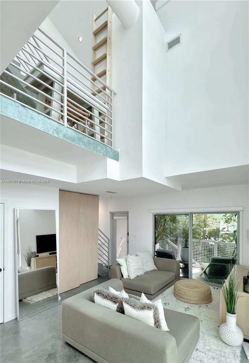 Modern Tri-level townhouse loft style 2 bedrooms, 2.5 bath with 1428 sq feet under A/C residence. Space boasts soaring 28' ceilings, completed with luxury finishes and appliances in South Beach.The second level offers 2 comfortable bedrooms with in-suite bathrooms plus washer and dryer. Dramatic floor-to-ceiling, impact resistant windows and stained concrete flooring throughout. Includes 1 covered assigned parking in a gated garage. Walking distance to the beach, Flamingo Park, Lincoln Road, shops and restaurants. Publix, Total Wine and Whole Foods are just around the corner. Quiet and secure boutique building with only 7 units without the hassle of high rise living. Generating $6600 per month. Very low maintenance fee