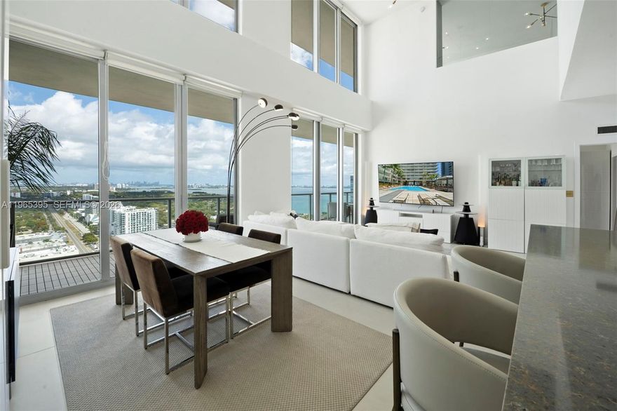 Turn the key to this fully renovated duplex penthouse at coveted 2Midtown, where soaring double-height ceilings and floor-to-ceiling glass showcase sweeping Biscayne Bay views and exceptional natural light. PH102 offers 2,178 SF with 2 bedrooms + den, 2.5 baths, generous storage, and 500+ SF of private terraces for effortless indoor-outdoor living. Both levels are elevator-accessible. Two assigned parking spaces included.

Finished in refined contemporary style, the home features 36x36 porcelain floors downstairs, wide-plank wood-look porcelain upstairs, fresh paint, new baseboards, and polished concrete ceilings. The reimagined kitchen boasts custom cabinetry, a quartzite waterfall island, Bosch appliances, and LG washer/dryer. Both primary baths are fully renovated with floor-to-ceiling porcelain, frameless glass showers, custom vanities, and a new soaking tub upstairs. The powder room is refreshed with quartz and designer wallpaper. Additional upgrades include brass hardware, new lighting, solid wood doors, a glass-enclosed den, automatic blackout and sun shades, and a new A/C system.

2Midtown offers 24/7 concierge and security, a rooftop bay-view pool, fitness center, sauna, steam room, hot tub, plunge pools, cabanas, playground, EV charging, and more steps from the Design District, Wynwood, and Midtown’s best dining and shopping.