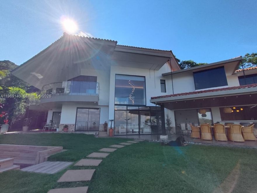 Fully remodeled luxury residence in the exclusive Colinas de Arroyo Alto community, Km 1 Via Dapa, Cali, Colombia. Situated on a 2,130 m² lot (approx. 22,900 SF) with 530 m² (approx. 5,700 SF) of construction, this elegant two-story home blends modern architecture with refined finishes and high ceilings throughout.

The first level offers formal and auxiliary living areas, a guest bedroom, and a designer kitchen featuring wood detailing and premium sintered stone surfaces. The second level includes a spacious TV lounge and three bedrooms, each with walk-in closets and en-suite bathrooms. The primary suite features a private balcony and sitting area.

Porcelain tile flooring (90x90), indirect lighting throughout, curated wall textures, and a harmonious color palette create a sophisticated ambiance. The property also includes parking for up to 10 vehicles, a separate guest residence above the garages, and 25 solar lamps surrounding the home. Renovation completed December 2025.

Price in Colombia: COP $4,500,000,000. USD price subject to exchange rate adjustment at time of contract. Owner open to receiving Miami property as partial payment.