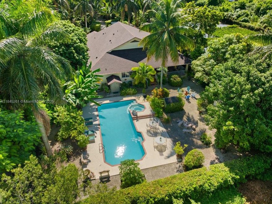 Welcome to your private tropical oasis in the heart of Redland. Recently appraised, this 2002-built estate sits on nearly an acre of lush, landscaped grounds, blending refined living with a sustainable lifestyle.

The main residence offers 3 bedrooms, 2.5 bathrooms, plus a flex space that can serve as an optional 4th bedroom, office, or guest suite. Interior highlights include cathedral ceilings with exposed wood beams, French doors, a wraparound porch, and a chef’s kitchen with white cabinetry, wall oven, and ample storage. The primary suite is spacious and serene, and all bathrooms throughout the home are extra large, offering comfort and functionality.

Outdoor living truly shines with a 16x40 resort-style pool and spa, a professional outdoor kitchen, mature fruit trees, and ample space for gardening or small-scale farming. Additional features include a full two-car garage with an attached carport, RV and boat parking, and a large detached shed with power and water, ideal for a workshop or storage.

Recent upgrades include a new roof, new pool pump, and hurricane protection. The property is serviced by well and septic, has no HOA, and is conveniently located minutes from shopping, dining, and top-rated schools.