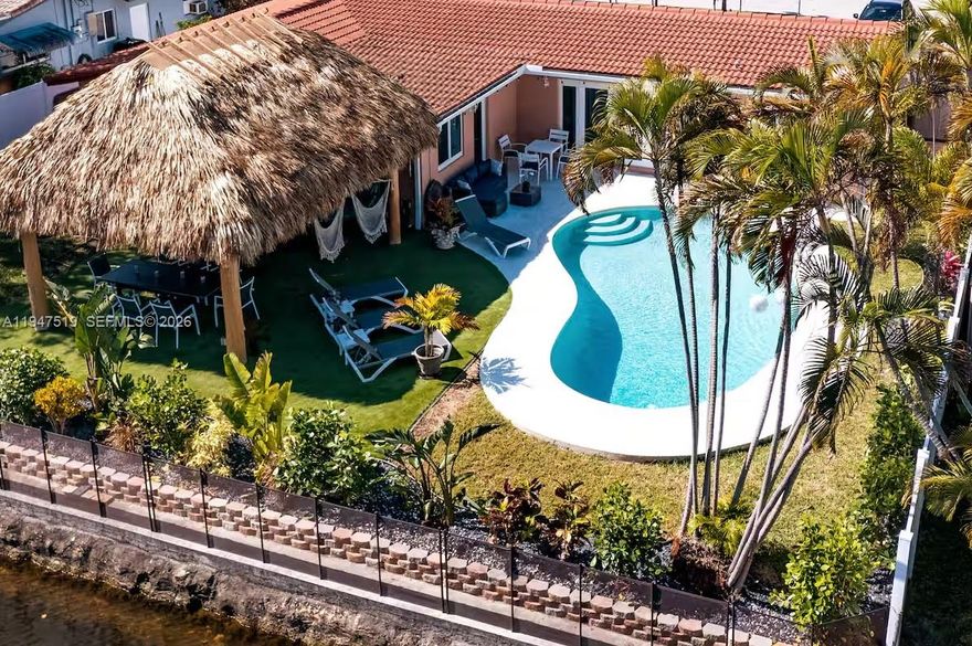 Experience resort-style living year-round in this exceptional canal-front home with impeccable landscaping. Thoughtfully updated and professionally designed, this residence features newer saltwater concrete heated pool, private floating dock, and a charming very private expansive backyard with oversized Tiki—perfect for relaxing or entertaining. Enjoy peace of mind with a newer roof, hurricane-impact windows and doors installed in 2022, and a new AC system. EV charger installed and the whole house is pre-wired for the generator. Meticulously maintained house, freshly painted interiors complement the home’s modern, coastal aesthetic. Ideally located in a highly desirable area, close to shopping, dining, entertainment, and major conveniences. This is waterfront living at its finest—where comfort, style, and location come together seamlessly.