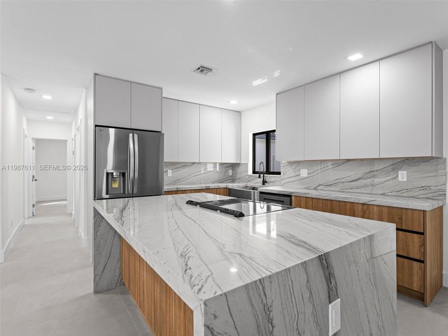 Immaculate almost-new construction offering 7 bedrooms and 4 bathrooms with high-end finishes throughout. This fully remodeled home features a new flat tile roof, impact windows and doors, and is fully fenced for privacy. Interior highlights include large porcelain tile flooring and a stunning designer Italian kitchen with quartzite countertops and cooking island, smart stainless steel appliances, microwave drawer, wine cooler, and bar/coffee station. Custom European cabinetry is featured in closets, while the bathrooms showcase porcelain tile, modern shower glass panels, smart toilets, and LED mirrors for a sleek spa-like feel. The home also includes a separate laundry room, new AC system, and tankless water heater. A private in-law suite or potential rental unit offers 2 bedrooms, 1 bathroom, kitchenette, and separate entrance. In addition, the right wing of the home could be rented out for additional income stream. The expansive backyard has room for a pool or jacuzzi and includes a concrete slab ready for a pergola or outdoor entertaining area. Custom driveway with decorative rock design and ample parking. Fit for an investor looking to make at least 3 different rental incomes, 14+ AIRBNB home or multi-generational family looking to live under 1 roof and split expenses. Centrally located in the heart of Miami, minutes from Sunny Isles beach and major highways. No HOA. Schedule to see it now while it last.