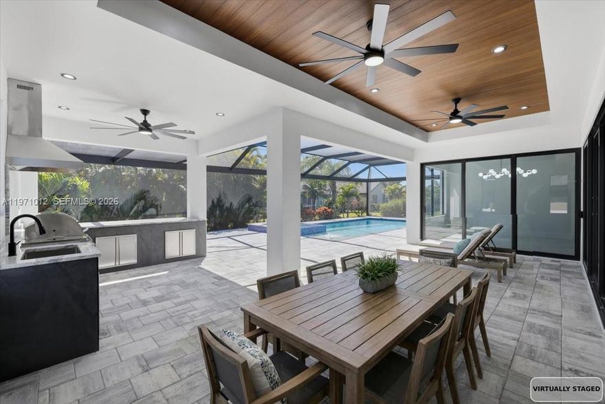 Experience elevated Florida living in this stunning new construction luxury residence with custom design & details throughout. Spacious 3 bedrooms, 3 full baths, plus a private den—perfect for a home office or flex space. Designed with impressive volume ceilings and an open layout, this home blends sophistication with modern functionality. Expansive impact windows and doors flood the home with natural light while providing peace of mind and energy efficiency. The gourmet chef’s kitchen is designed to impress, offering an abundance of high-end cabinetry, quartz counters, premium appliances and dedicated wine and coffee bar. Outdoors, enjoy your own resort style oasis with custom heated pool & spa, premium picture window screen enclosure and a professionally designed true summer kitchen & eating bar. Ambiance lighting creates the perfect setting for alfresco dining and sunset entertaining. Retreat to a spa-inspired primary en-suite with dual rainfall shower heads and a large freestanding soaking tub, smart toilet, dual sinks and walk-in closets with custom built-in organizational systems. Each additional bedroom offers comfort and privacy with access to well-designed en suite bathrooms. A well-appointed laundry room with abundant storage supports effortless daily living. The oversized three-car garage with epoxy floors. Luxury, innovation, and exceptional craftsmanship come together in this remarkable new construction home. Designed for today’s discerning buyer.