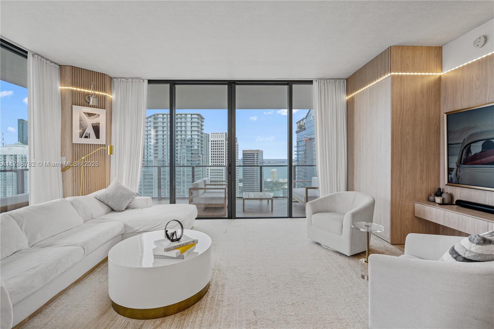 Experience luxury living at Brickell Rise with stunning water views and an unbeatable location. This 2-bedroom, 2.5-bathroom corner unit on the 34th floor features a coveted floor plan and exceptional design. The minimalist interior boasts custom woodwork, high-end finishes, and a seamless flow. The brand-new Italian kitchen includes custom cabinetry, Bosch appliances, and elegant wood accents. The Smart Home features dimmable LED lighting and bespoke furniture.
Wraparound balcony offers panoramic water views of Fisher Island, Biscayne Bay, and the Miami River. The primary suite includes custom design elements and spacious walk-in closets, while the primary bathroom offers a spa-like retreat with a jacuzzi and walk-in shower.