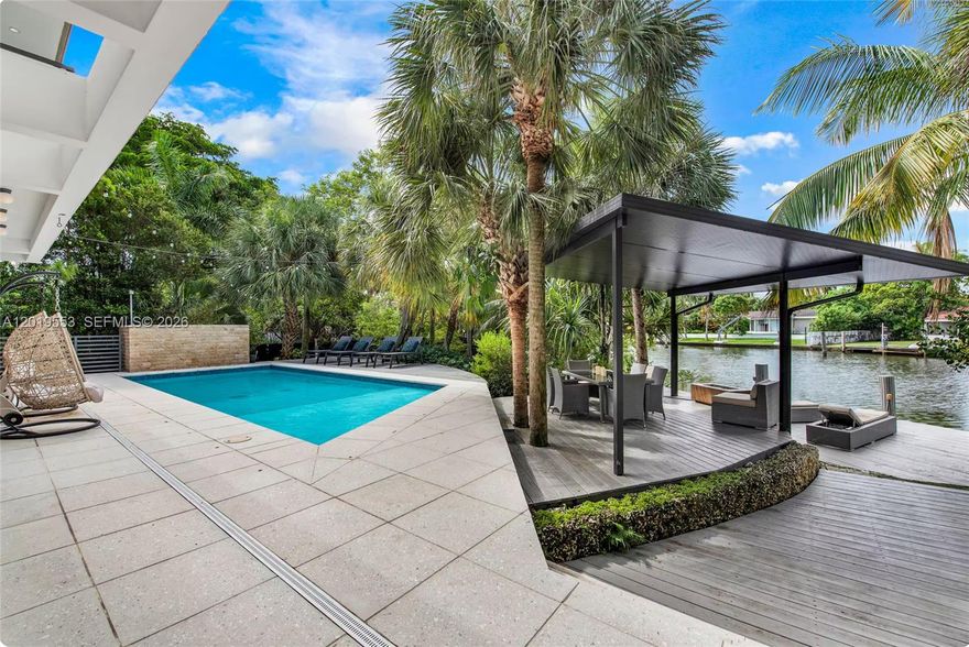 Unique opportunity to own a modern two-story elevated home built in 2015, featuring  5 bedrooms, 4 en-suite bedrooms with private balconies, and 4.5 bathrooms. This extraordinary 36,369sf DOUBLE -LOT oasis transports you into a tranquil, lush tropical paradise. Each bedroom door is a 300-year-old handcrafted art piece imported from Bali, adding warmth and character throughout the home. Outdoor amenities abound with 175 feet of waterfrontage, a boat dock, private beach, resort-style pool, children’s playhouse, oversized chess game, volleyball area, and basketball hoop — creating the perfect setting for relaxation and entertainment. The open-concept living and dining areas flow seamlessly into a gourmet kitchen equipped with premium Gaggenau appliances. Floor-to-ceiling high-impact windows and sliding doors invite abundant natural light and effortless indoor-outdoor living.
Ideally located across from Belle Meade Island, this one-of-a-kind waterfront retreat offers privacy, luxury, and an unmatched lifestyle.