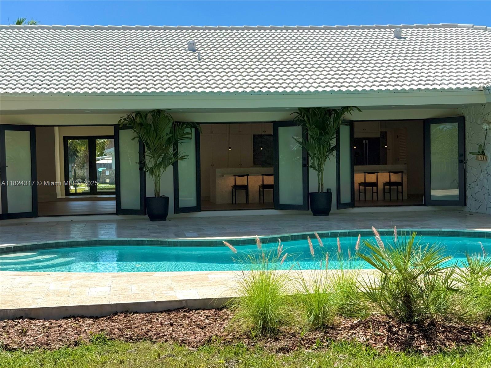 Meticulously renovated split plan Palmetto Bay home by husband and wife architectural design team. Reimagined for modern living with open kitchen featuring marble 16' marble kitchen island that seats up to 7. Home features include impact windows and doors, 3 car garage, engineered oak wood floors, shell stone tile, large open kitchen concept with new SS appliances and volume ceilings, all PVC plumbing, new ACs, and beautiful open redesigned pool area. Dining room could possibly be used as an office also. This home is a split plan layout with 3/2 on one side and a 1/1 on the other. New beautiful landscaping in both the front and back yard for your enjoyment under the covered patio. Main space of the home connects with the outdoors through a series of 3 double doors to bring the outside in.