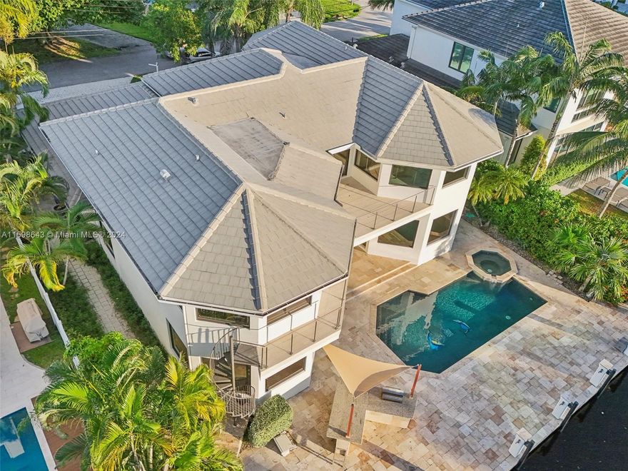 This exquisite smart home features a modern design with an open floor plan, high ceilings, loft area, Control4 automation, large island in kitchen with natural gas, seamless access to the outside pool area, TV room, family room, and custom bar. Five bedrooms, fifth converted to an office, home theatre, music room, dining area, and fireplace. Master suite with pool views, a luxurious bath, steam shower, and walk-in closet. With 80' of water frontage, new dock, pool, and spa. Located in prestigious Seven Isles with 24/7 security, close to top schools, beach, dining. The 3-car garage with room for lifts. Year 2018 built refers to a major remodel, ensuring a blend of modernity and timeless elegance.