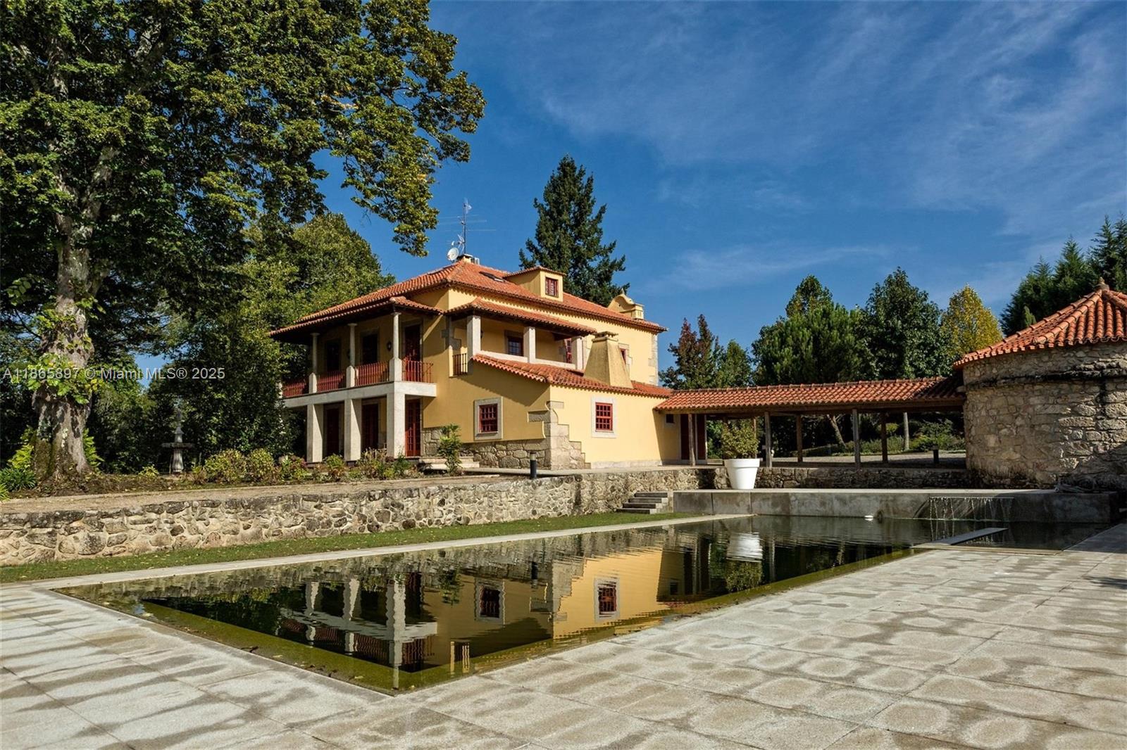 Impressive estate in Tondela with 7.9 hectares of land and 811 sqm of covered area. It offers two main houses: the original granite manor with 400 sqm across three levels, featuring hall, kitchen, dining, living, gym, storage, one suite and three bedrooms; and a modern 507 sqm house built in 2008 with office, kitchen, dining/living, elevator, two suites with river views and a service apartment. The property includes gardens, pool, and parking for 30 cars. Just 1 km from Tondela, 2h30 from Lisbon, 1h15 from Porto, 1h30 from Serra da Estrela. The award-winning Ecopista do Dão passes in front, and golf is 12 km away. Ideal for private living or tourism investment.