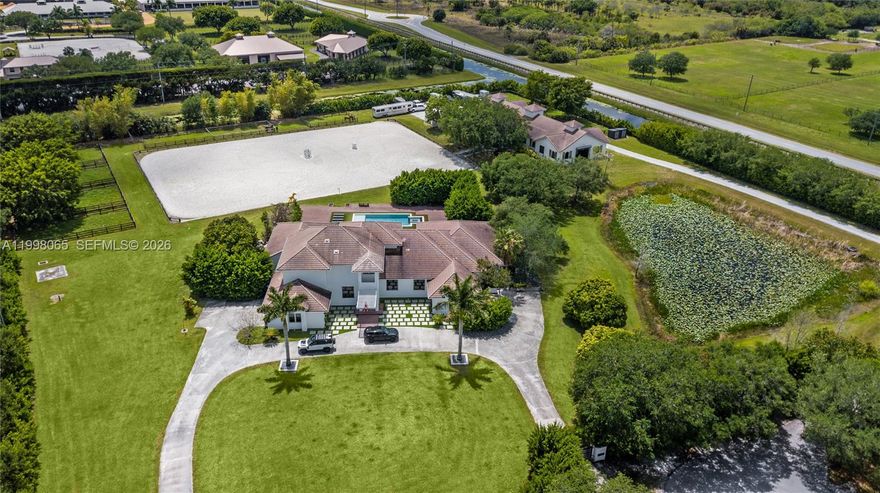 Breathtaking contemporary estate in Palm Beach Point set on over 7 acres of prime equestrian land. This exceptional property features soaring 30-foot ceilings, 8 spacious bedrooms, 9 bathrooms, plus 2 studio staff or grooms quarters in the barn with full kitchen and baths.
Designed with both luxury and functionality in mind, the property includes a brand-new 12-stall center-aisle barn complete with tack room, feed room, laundry room, and two wash and grooming stalls. Nine irrigated grass paddocks provide ample turnout, while the impressive 230 x 150 arena is finished with premium Martin Collins “Clopf” footing.
A stunning pool overlooks the arena, creating the perfect balance between high-end living and world-class equestrian facilities.