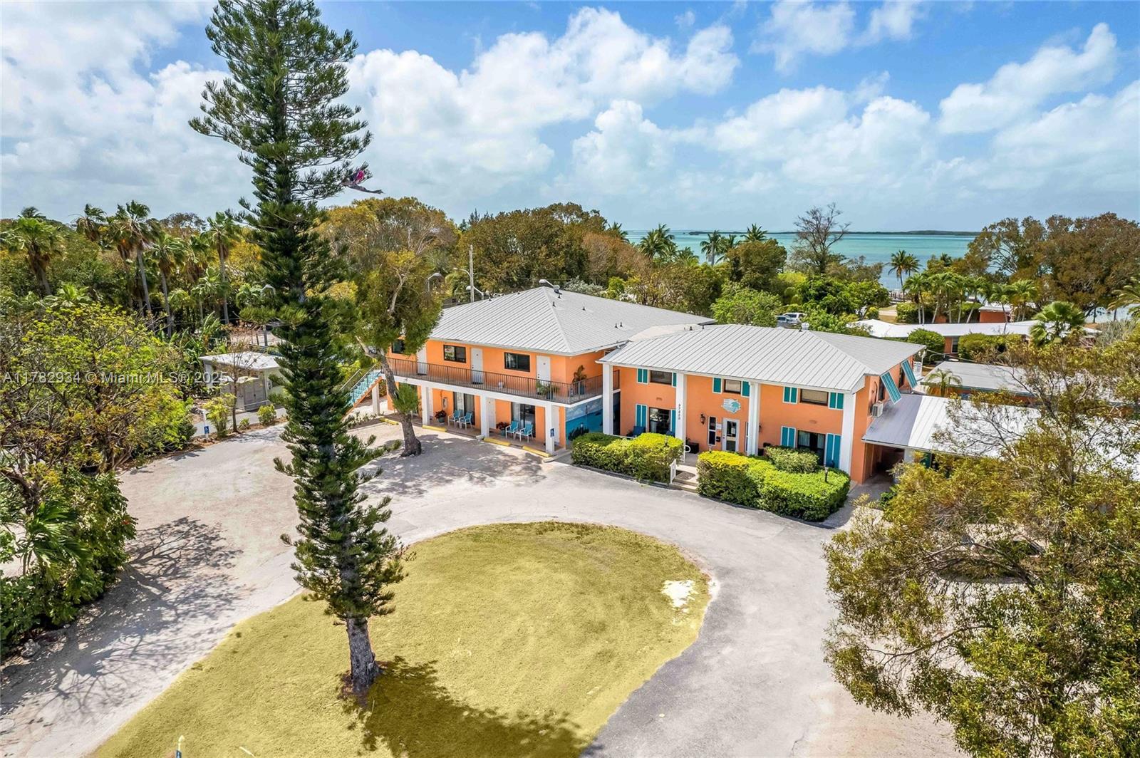 Opportunities like this are few and far between. Nestled on nearly 3 acres stretching from Overseas Highway to the sparkling waters of Florida Bay, this 21-room boutique hotel is a true hidden gem in the heart of Key Largo. Zoned Suburban Commercial and family-owned/operated for 35 years, this is one of the rarest bayfront hospitality offerings available in the Upper Keys. The property boasts direct bay access with dockage, a private beach, boat ramp, concrete pool, outdoor grilling area, and tiki huts—set against postcard-perfect sunset views. 11 of the rooms have been fully renovated with coastal modern kitchens, bathroom tile, and furniture, while the remaining rooms have been freshly painted, furnished, and decorated - offering immediate rental income with room to elevate and expand.