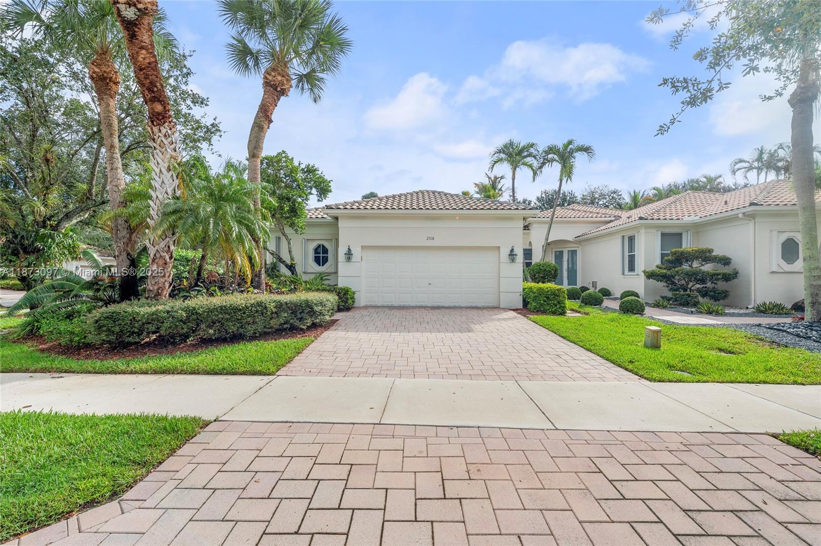 Set on a quiet corner in Bay Pointe at Weston Hills CC, this well-kept one-story home offers 3BD/3BA and natural light. Inside, volume ceilings and large windows frame serene garden views. Porcelain-tile living areas; kitchen with white cabinetry, stone counters, and breakfast nook. Private primary suite with wood flooring, sitting area, and spa bath with Roman tub, separate shower, and dual sinks. Guest bedroom with wood flooring. Custom California Closets throughout the home. Outdoors, a screened patio spans the back for al fresco dining. Spacious backyard has room for a pool and a summer kitchen. Recent updates: water heater 2024, A/C 2020, full accordion shutters. The association maintains landscaping, sprinklers, exterior paint, and pressure cleaning.