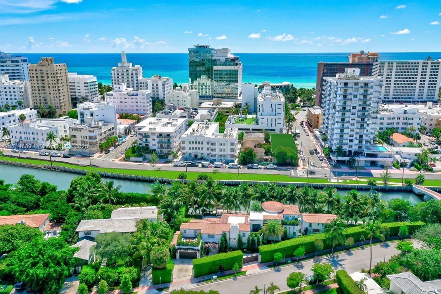 Walled & gated with 300 ft of waterfront. Approx. 20,000 SF lot, every inch landscaped and lit. Live fun in this amenity rich home. Exuberant interiors are playful and plush! Each creatively chic space says Power Player. Double height ceilings read light and airy.  Ultra cool custom bar. Separate large built-in wine display. Volume ceilings and walls of glass in impressive kitchen/dining area + outdoor grill & patio. Dramatic master, sitting room,13-foot ceilings + 3 terraces. 2-story guest villa. 2-car garage. Surveillance & security system. State-of-the-art gym & red light sauna, oversized pool & dock. It's always a perfect day on Flamingo Drive… kayak, skate, bike, or walk across foot bridge to ocean, hotels, dining, beach clubs, and more. All this & just a mere 15 mins to int’l airport