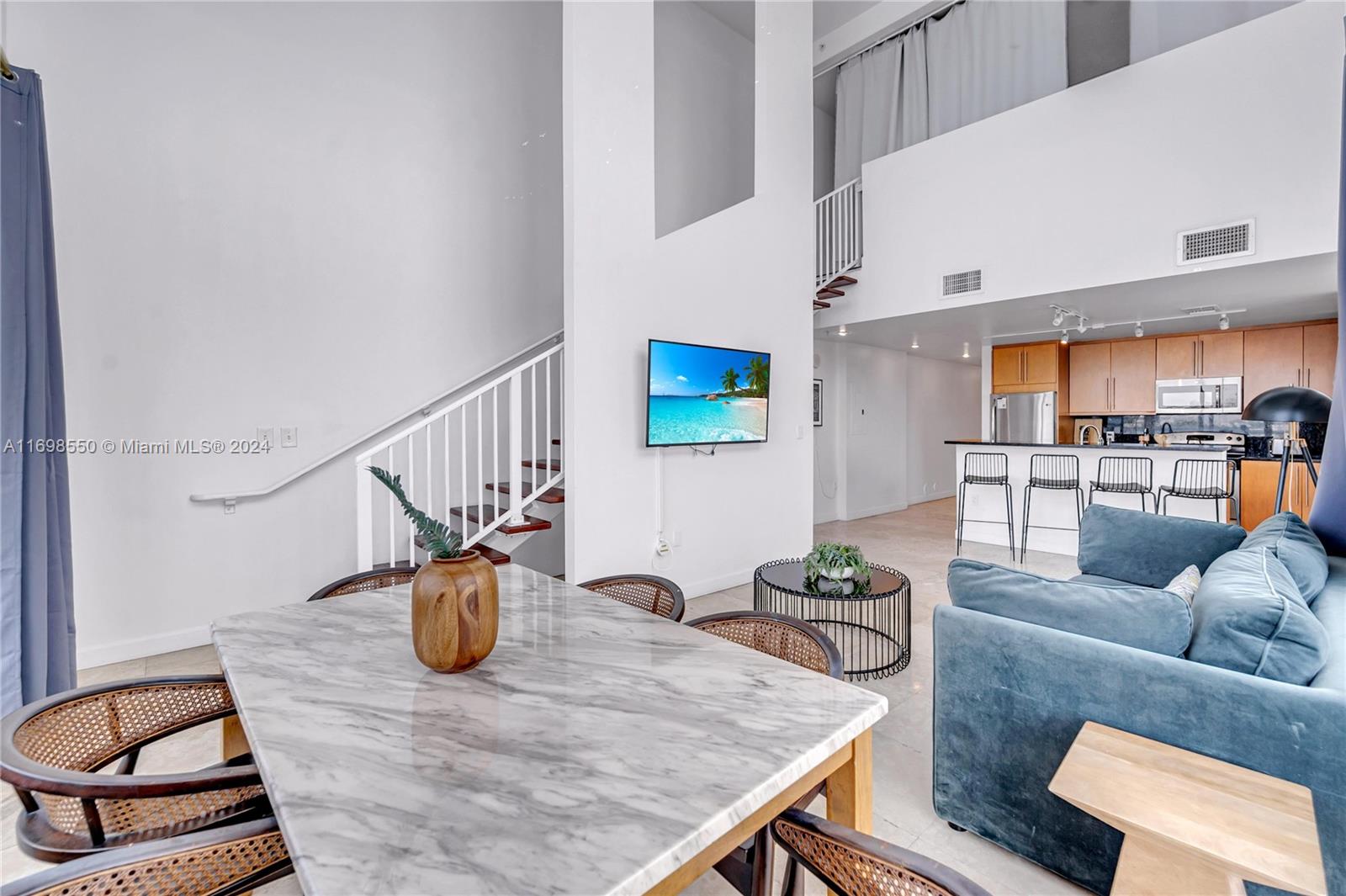 This middle-unit 2-bedroom, 2-bathroom, two-story loft offers 1,524 sq ft of living space with modern finishes and open water views. Located in North Bay Village, this waterfront building has 15 exclusive two-story units, including a penthouse with panoramic Biscayne Bay views. North Bay Village is a growing area, with new developments like the Ritz-Carlton Residences nearby. Units feature floor-to-ceiling windows, 20-foot ceilings, and breathtaking water views. Each unit comes with two covered parking spaces. The building also offers amenities like a gym, pool, sauna, and two elevators. Furniture may vary by unit.