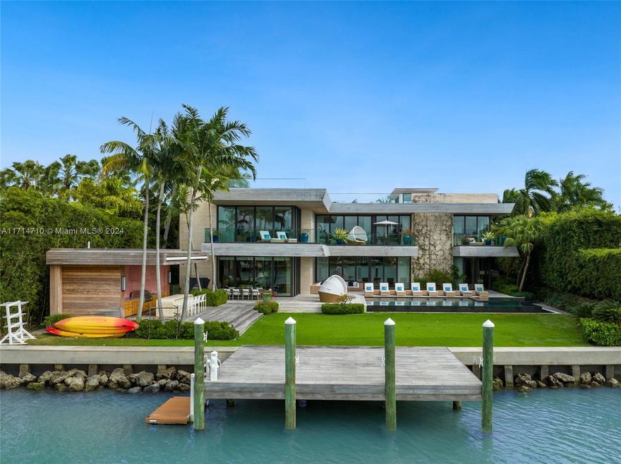 This waterfront estate on prestigious North Bay Road is a masterpiece of ultra-luxe tropical modernism. Designed by Choeff Levy Fischman, this extraordinary 13,662 sq ft home seamlessly integrates indoor/outdoor living w/ sliding glass walls, light filled atrium, bayfront breezes throughout, & expansive roof deck. This turnkey home w/ 100’ of waterfront featuring brand new kitchen w/ custom twin islands & Wolf appliances, elegant millwork, multiple entertaining / dining areas, wine cellar, infinity pool, outdoor cabana w/ grill & roof deck. Floorplan features 7 beds on 2nd floor, 2-bed guest wing & multiple rooms w/ direct bay views. Principal bedroom features twin bath/closets & terrace. Additional features include gym, home theater, 3-car garage, boat dock & lush landscaping.