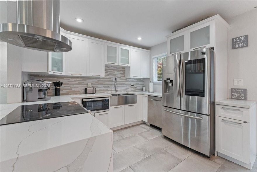 SUN-FILLED SPACES, SMART UPGRADES, AND EFFORTLESS SOUTH FLORIDA LIVING. This Turnkey Corner-Lot Home Offers Bright, Open Living Areas Filled With Natural Light And Sleek Porcelain Tile Throughout. Dual Driveways Provide Ample Additional Parking With Space For Cars, A Boat, Or An RV — A Rare And Valuable Feature.

The Updated Kitchen Features Quartz Countertops, Custom Cabinetry, And Premium Appliances, Creating A Seamless Flow For Everyday Living And Entertaining. The Spacious Primary Suite Serves As A Private Retreat With Its Own Climate Zone, A Walk-In Closet, And A Spa-Inspired Bath Complete With A Wet Room, Multifunction Shower, And Hydrotherapy Microsilk Tub. Dual Climate Zones Provide Comfort Throughout The Home.

Step Outside To A Pergola-Covered Patio And A Backyard With Plenty Of Space To Customize And Make Your Own. Additional Highlights Include Impact Windows & Doors, A 2019 Flat Roof, Updated Systems, And A Tankless Water Heater. Conveniently Located Near Wilton Drive, Beaches, Dining, And Entertainment.