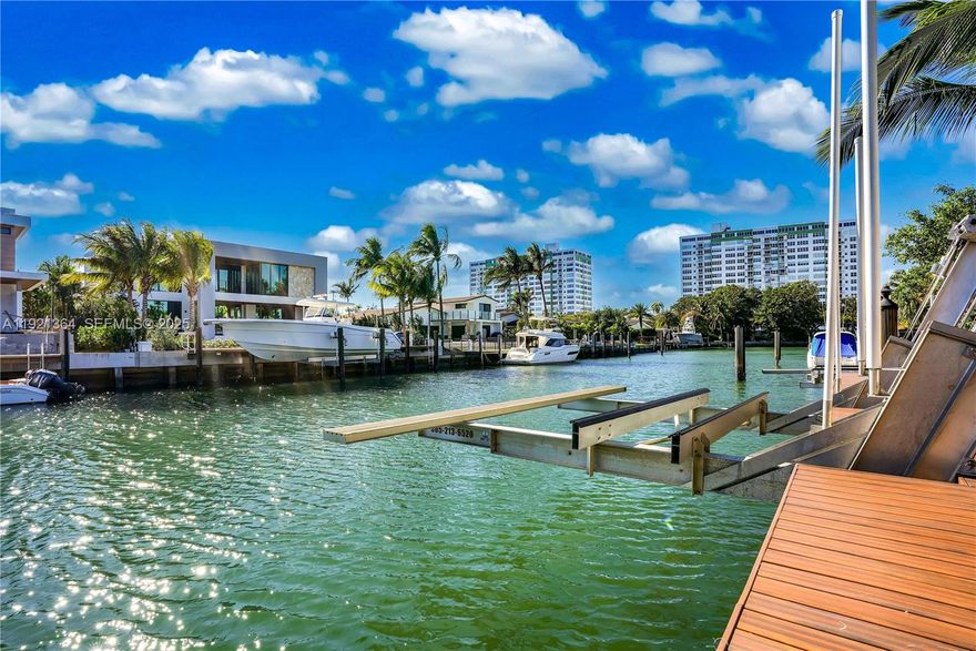 A Boater’s Dream in Prestigious Sans Souci Estates! This spectacular contemporary deep-waterfront residence has been fully renovated and is truly move-in ready. Located just minutes from Haulover Inlet, the Miami sandbar, Biscayne Bay, and the ocean, this home offers 75 feet of prime waterfront with an upgraded dock, seawall, and multiple boatlifts. Step inside to discover a bright, open floor plan adorned with marble/travertine stone floors, striking accent walls, European-style kitchen cabinetry, and stainless-steel appliances. The home features sophisticated bathroom designs, impact windows and doors, and recessed lighting. Upgrades include a brand-new roof, new AC system, fiber-optic connectivity, and a 12-camera security system with Ring components. A 2-car garage with built-in storage adds convenience and functionality. Electric and piping fully updated. The outdoor experience is truly exceptional. Enjoy an expansive pool and patio area with a tranquil waterfall installation, a brand-new covered Jacuzzi, and a chef-designed outdoor kitchen with premium stainless-steel appliances beneath a tropical tiki. Resort-style backyard ambiance—perfect for entertaining or unwinding in total comfort. Ideally situated just minutes from Bal Harbour Shops, world-class beaches, Aventura, the Miami Design District, Wynwood, top schools, and both Miami and Fort Lauderdale airports— a central location to everything Miami has to offer.