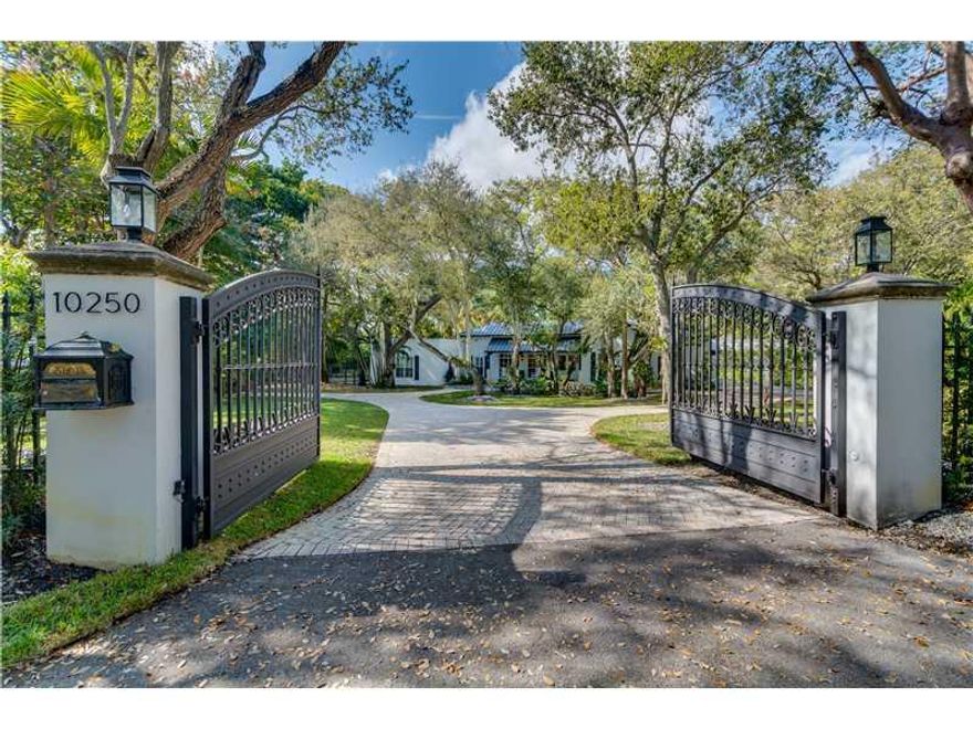 Absolute perfection in paradise! The epitome of So. Fla. living on a gated tropical acre+. Completely redesigned & expanded in 2011 with the finest materials. This home offers everything one could ask for...entertain casually in the family style amazing c hef's kitchen that opens to the main section of the home, formally in the dining room connecting to the butler's pantry, casually at the fully equipped outdoor summer kitchen overlooking the 46' heated saline pool or nestle w/a book in the library-bar rm.