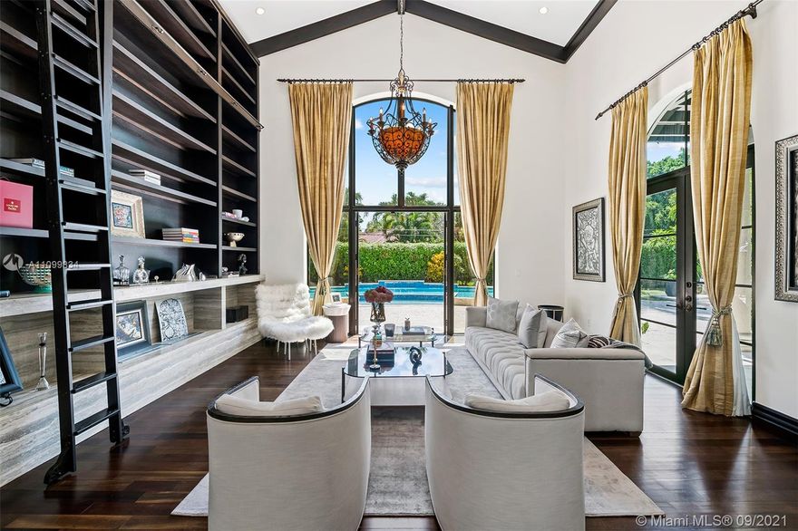 Distinguished estate on a manicured builder's acre in the heart of Pinecrest delivers utmost privacy. This extravagant walled and gated residence, spread over 9,200 sf of living space, boasts a grand foyer entrance, soaring ceilings, and a separate guest wing. Living room with custom library wall and eco fireplace. Gourmet kitchen w/breakfast area, Wolf appliances, Taj Mahal quartzite, formal dining, media room, spacious family room, office, opulent primary suite w/attached den. Expansive backyard ideal for entertaining w/saline pool, splash area, lanai, summer kitchen, large game room. Many updates incl. water purification system, sound system, generator, 3-car garage, plenty of guest parking. Superb private/public schools nearby. Quintessential South Florida grand luxurious living.