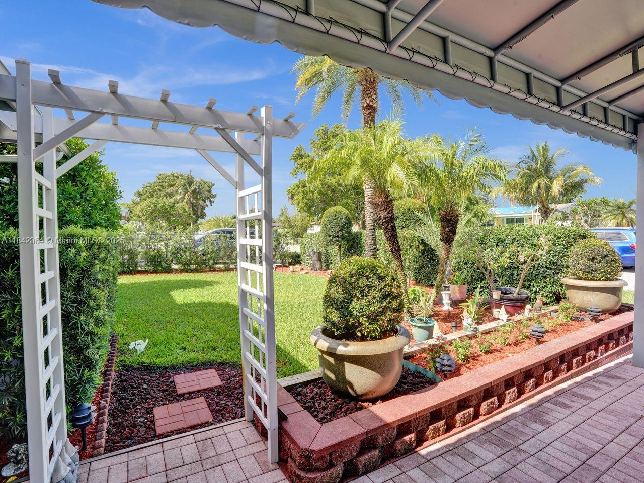 This is a fantastic opportunity—perfect for first-time homebuyers or anyone looking to downsize! This charming and spotless home features a beautifully maintained, fenced yard with no HOA! The front of the home offers a permitted 2-car canopy, plus space for two additional vehicles. Sprinklers on well with timer. and landscape lighting. You'll be welcomed by lush palm trees and vibrant plants that add to the tropical curb appeal. Enjoy complete privacy in the backyard, ideal for relaxing or entertaining and 2 spacious sheds for storage (10x8 and 10x12). Inside features renovated kitchen, bathroom, new flooring, & freshly painted. Blocks to Parks, Publix, Movie Theater, Elem. & Middle schools. Roof 2021, Brand New Front Door and Electrical updated plus NO Flood ins. required