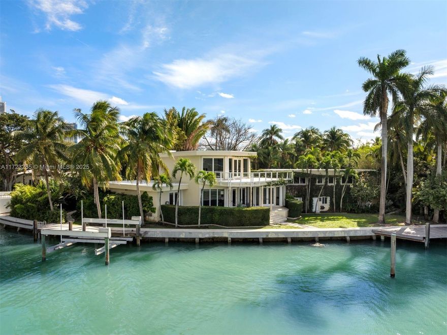 Build the waterfront estate of your dreams on coveted North Bay Road. This exceptional property spans 18,692 square feet with 159 feet of pristine bayfront, offering an unparalleled canvas for crafting a world-class retreat. The existing 6,637 SF residence features 4 bedrooms, 5+1 bathrooms, and timeless architectural details. The open living, dining, and kitchen areas showcase breathtaking Biscayne Bay views, while the primary suite offers panoramic sunsets, a spacious marble-clad bath, and an expansive walk-in closet. The exterior includes a private dock with boat lift and a lush garden, perfect for enjoying Miami’s coastal lifestyle. Build new or reimagine the current home to embody Miami Beach’s luxurious coastal lifestyle, just minutes from top dining and entertainment.