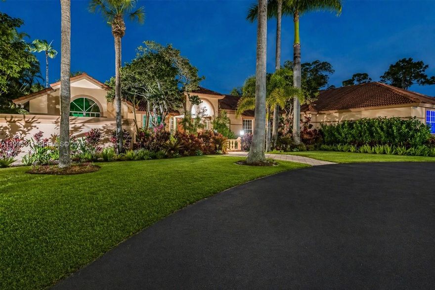 Experience luxury lakefront living in this extraordinary custom estate located within one of Coral Springs’ most exclusive gated communities. Situated on over an acre with breathtaking water views, this one-story residence offers over 5,200 SF of living space with 6 bedrooms and 5.5 bathrooms. A dramatic entrance featuring a stunning water feature and bridge-style walkway leads into expansive living spaces filled with natural light, marble flooring throughout the main areas, and rich Brazilian cherry wood floors in the bedrooms. Designed for both elegant entertaining and comfortable everyday living, the home features spacious formal and casual living areas, a grand dining room, and an updated kitchen with custom wood cabinetry, granite countertops, and stainless steel appliances. The expansive primary suite offers a private retreat, while the additional bedrooms are thoughtfully tucked away on the opposite side of the home, creating exceptional privacy and functionality. Oversized windows showcase serene lake views throughout, while the resort-style outdoor space features an expansive covered patio, lakefront pool, and endless room to relax and entertain in complete privacy. A rare opportunity to own a true custom estate that combines timeless architecture, exceptional space, and an unmatched setting in South Florida.