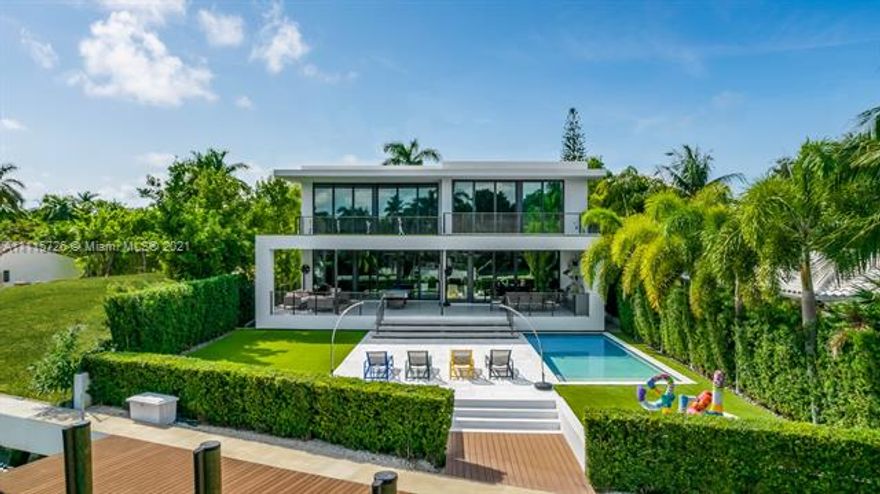 Tropical modern home built 2019 top level finish. 11,527sqft lot w/71ft on the water, breathtaking open floor plan of 6,393sf living space and 10ft ceilings. The living room has luxurious paneled walls, floor to ceiling impact windows open to oversized covered terrace bbq area for entertaining and enjoying views. Mia Cucina kitchen Wolf and Subzero appliances wine cooler. Oversized laundry room steam dryer. Cameras, sonos system and alarm. Spectacular floating staircase Italian imported floors throughout. All bedrooms have their own oversized bathroom. 3 bedrooms on the water with own balconies. Full top of the line media room and beverage center. Sparkling pool large grass area. Lush landscaping. New seawall and 500 sqft gorgeous dock (60ftX8ft). 2 car garage. Located with 24H guard gated