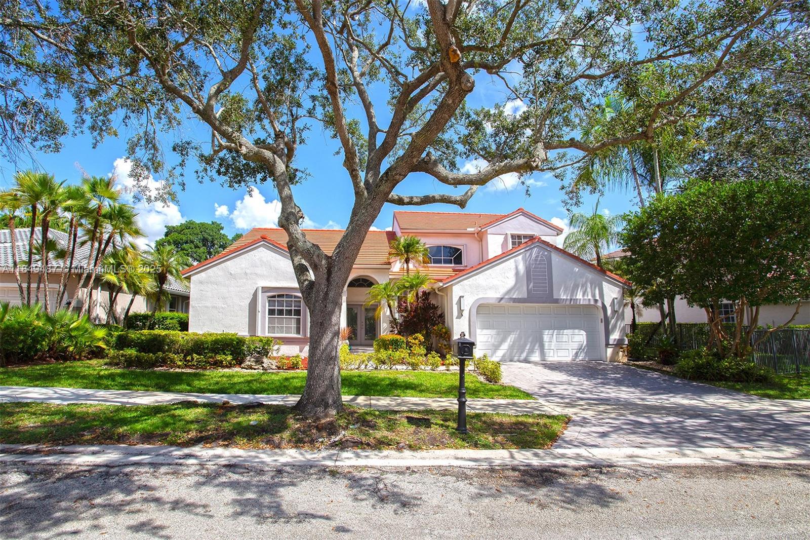 Elegant two-story home located in the prestigious Weston Hills community, featuring a south-facing front and a north-facing backyard. Soaring ceilings, French doors, large windows, and neutral tile flooring that add light. Two bedrooms are conveniently located downstairs, including a spacious primary suite with direct patio access. Upstairs, find two more bedrooms and a versatile loft perfect for an office, studio, or fifth bedroom. Roof replaced in 2018, A/C is 9 years old, and water heater is newer. The backyard is a private oasis surrounded by lush landscaping, no rear neighbors, and no golf traffic. Beautiful pool in a true resort-style setting. Ideal to personalize.