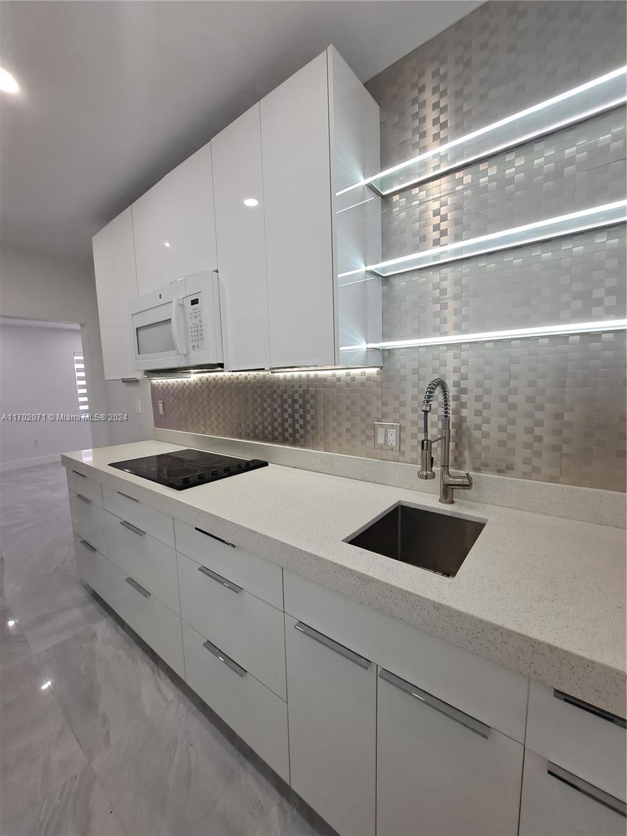 MOVE IN WITH 2 MONTHS ONLY!!! Vacant and easy to show on lockbox. Discover the ultimate rental experience in this completely renovated 1-bedroom apartment, ideally located near the beach. The modern kitchen features quartz countertops and state-of-the-art appliances, while the apartment offers brand new central A/C, impact windows, and a bathroom with smart technology. Enjoy the convenience of a washer & dryer in your unit. Benefit from assigned gated parking and additional parking spaces right across the street. Embrace luxury, comfort, and convenience all in one place!