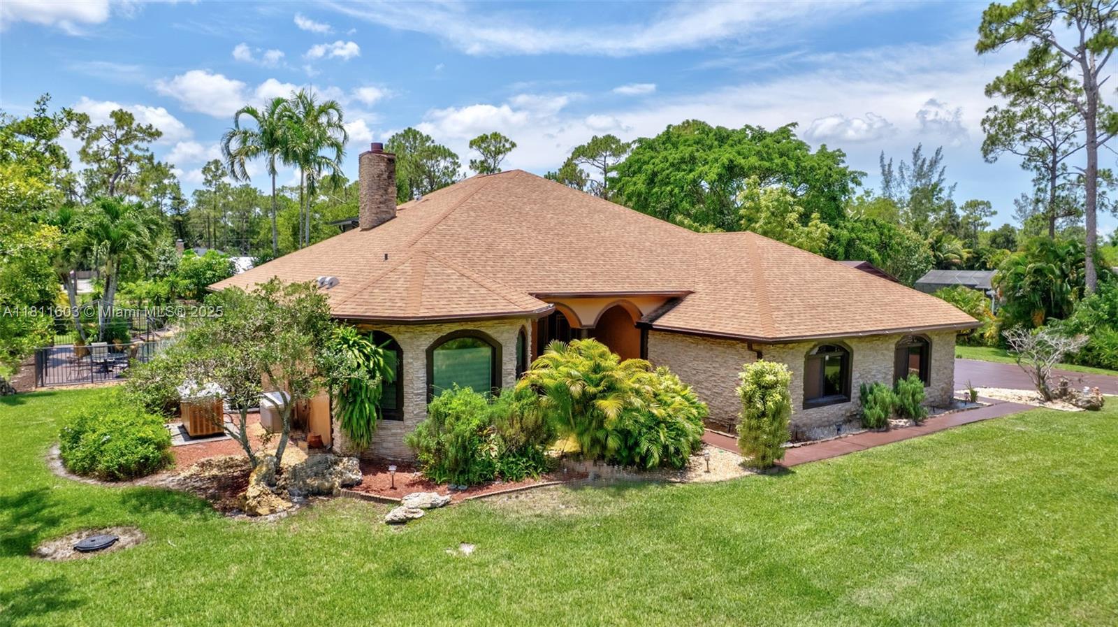 Enjoy luxury, privacy, and peace of mind in this custom-built 2007 estate home, nestled on a privately paved street & sitting on a fully fenced 1.15-acre lot: 4 bdrms, 4 bths, plus office/den. Features newer roof installed in 2022, brand-new AC & accordion shutters throughout, whole-house; brand new water filtration for the whole house, impact windows/doors. Convenient generator with 1,000-gal propane tank and 3-car garage (30’x33’). Enjoy a saltwater pool, 5-person spa, waterfall, and outdoor kitchen. Property has a powered boathouse, a long driveway & a fully equipped gas-powered summer kitchen, perfect for outdoor entertaining. Stone accents, fireplace & tranquil waterfalls in front & back create a peaceful, luxurious setting. Pool table & furniture is a bonus in the 2nd floor- Rec room