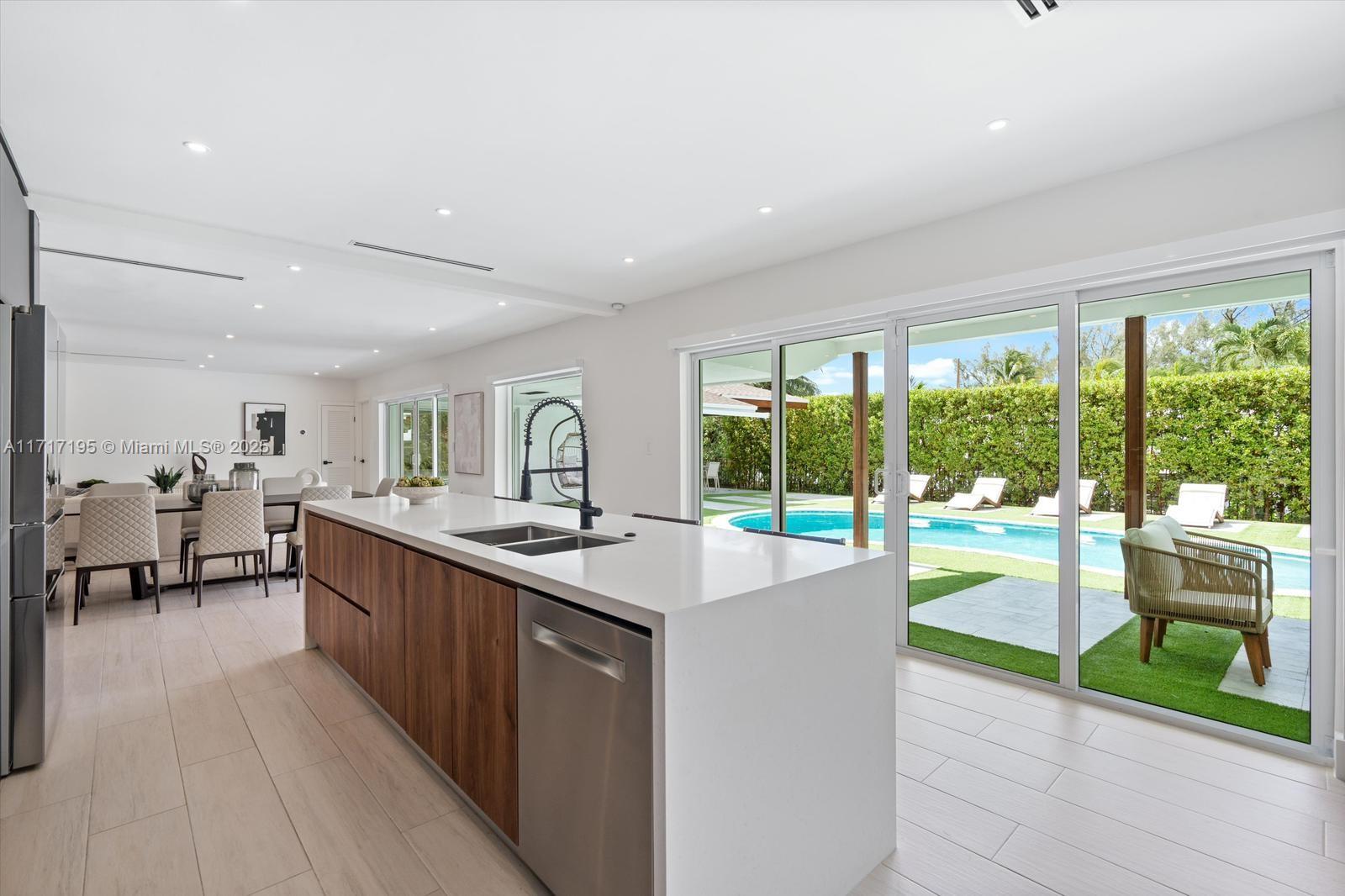 Discover luxury in the prestigious gated community of Enchanted Lakes. This Modern Contemporary home features an open, light-filled floor plan connecting indoor and outdoor spaces to a private oasis. The Chef’s kitchen boasts a 12-foot island, walk-in pantry, premium appliances, and a built-in coffee maker. Custom woodwork enhances closets, doors, a laundry room, and a built-in bar. This smart home features include Lutron Caseta lighting, automated shades, Nest thermostat, cameras, smart lock, and irrigation. Upgrades include new HVAC, plumbing, electrical, impact windows, designer landscaping, and a whole-house generator. A perfect blend of style and functionality!