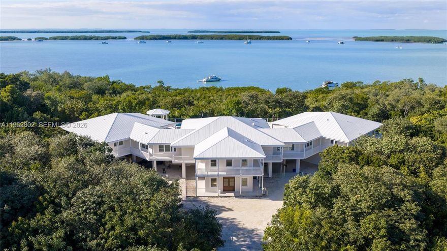 Introducing Isla House. A truly exceptional waterfront estate in the heart of downtown Islamorada, which exemplifies the serene beauty and elegance of Keys living. Set on a 5.82 acre double lot, Isla House overlooks 500+ feet of pristine Florida Bay waterfront. New custom construction melds traditional Caribbean architecture with clean modern aesthetics. The over 8,800 square feet of air conditioned living space is thoughtfully designed with bright open interiors which blend sophistication and comfort while framing breathtaking views of Florida Bay. You enter a sunlit two-story foyer leading you upstairs to a bespoke great room, encapsulating a dramatic vaulted wood ceiling, spacious living area, and a custom gourmet chef's kitchen. Floor to ceiling glass doors frame an unobstructed view of the spacious bay-view terrace, which features a 50 foot elevated infinity edge swimming pool and outdoor kitchen with bar. On the upstairs level you will also find a serene primary suite, five generous en-suite guest bedrooms, a powder room, and a large laundry room. The lower level offers a separate one bed en-suite with its own entrance and patio. A Media room with adjoining bathroom is the ideal flex space. A 1,600 square foot three car garage and a carport area completes the lower level. All told, there is nearly 25,000 square feet under roof cover. The estate's tropical grounds are designed to complement the home's architecture.