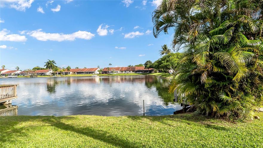 This updated, fully furnished,  2-bedroom, 2-bathroom, plus finished patio under AC that could be used as a 3rd bedroom, lakefront villa is located in a prime Hollywood location, offering a tranquil yet convenient living experience. The home has been beautifully renovated, featuring a modern kitchen with glossy, white cabinetry, stainless steel appliances plus an additional countertop and plenty cabinetry for storage. The villa has a glass enclosed patio with stunning views of the lake, making it perfect for relaxing and entertaining.