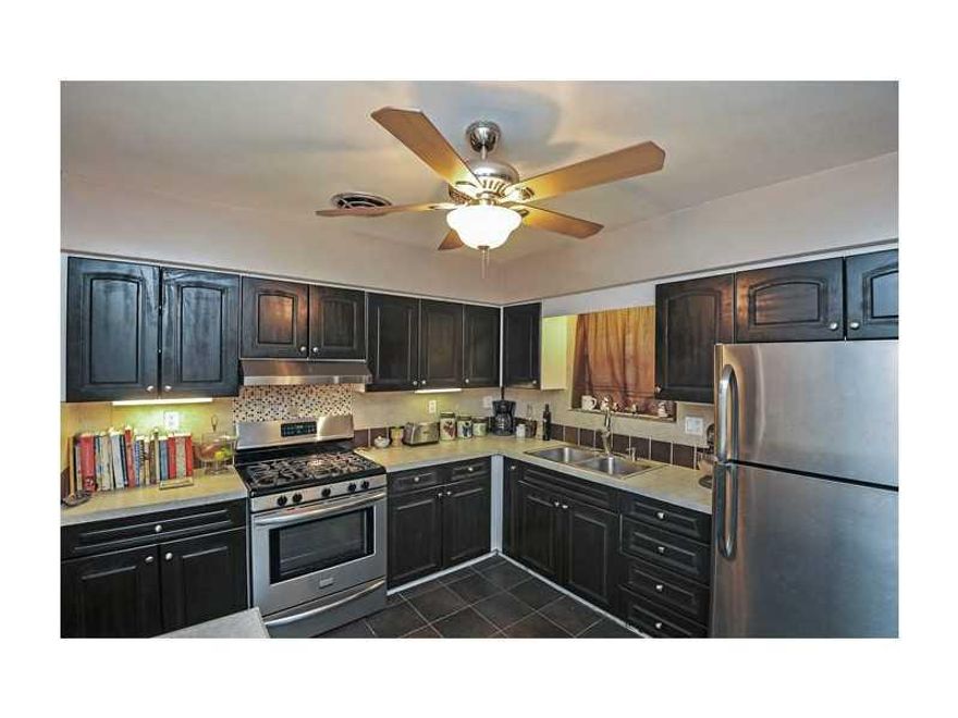 Lovely 3/2 w/a ton of updates inside: gorgeous restored original hardwood floors, gas operated tank-less water heater, Italian slate kitchen floor, S/S appliances including gas convection stove. Roman style bathroom with beautiful fixtures create your own  personal spa.  The living room is quaint and cozy with a beautiful slate gas fire place keeps you toasty that 1 week of winter!The massive yard is an oasis of mango, avacado, and banana trees with space for a pool, deck, addition, or more fruit trees!