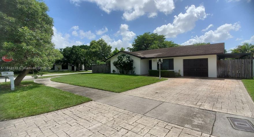 Charming corner-lot home in Calusa with 3BR/2BA main house plus a 1BR/1BA converted garage suite—ideal for guests or extended family. Located within walking distance to A+ Calusa Elementary and Calusa Estate Park. Features impact windows/doors, renovated kitchen and bath, and a newer A/C (2022). Enjoy shaded outdoor living under a spacious aluminum patio roof. Yard includes a sprinkler system fed by a well for water efficiency. Extra laundry room offers a brand-new washer, sink, and tankless water heater for on-demand hot water.