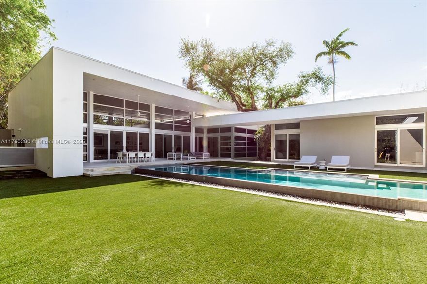 A stunning architectural gem in the gated enclave of Ye Little Wood, this modern 5 BD, 6.5 BA residence by award-winning architect Roney Mateu offers refined luxury in Coconut Grove. Thoughtfully designed to maximize space and light, the 6,803 SF estate sits on a lush 16,575 SF lot, featuring 17-ft ceilings, impact glass, and European finishes. The primary suite boasts dual walk-in closets and a spa-inspired bath, while a detached 1BD/1BA guesthouse with an office adds flexibility. This home blends elegance with seamless indoor-outdoor living. A resort-style lap pool, sun ledge, summer kitchen and covered terraces provide the perfect space for relaxation and entertaining. An adjacent lot is available for sale. Located moments from Coconut Grove’s top dining, shopping, and waterfront parks.