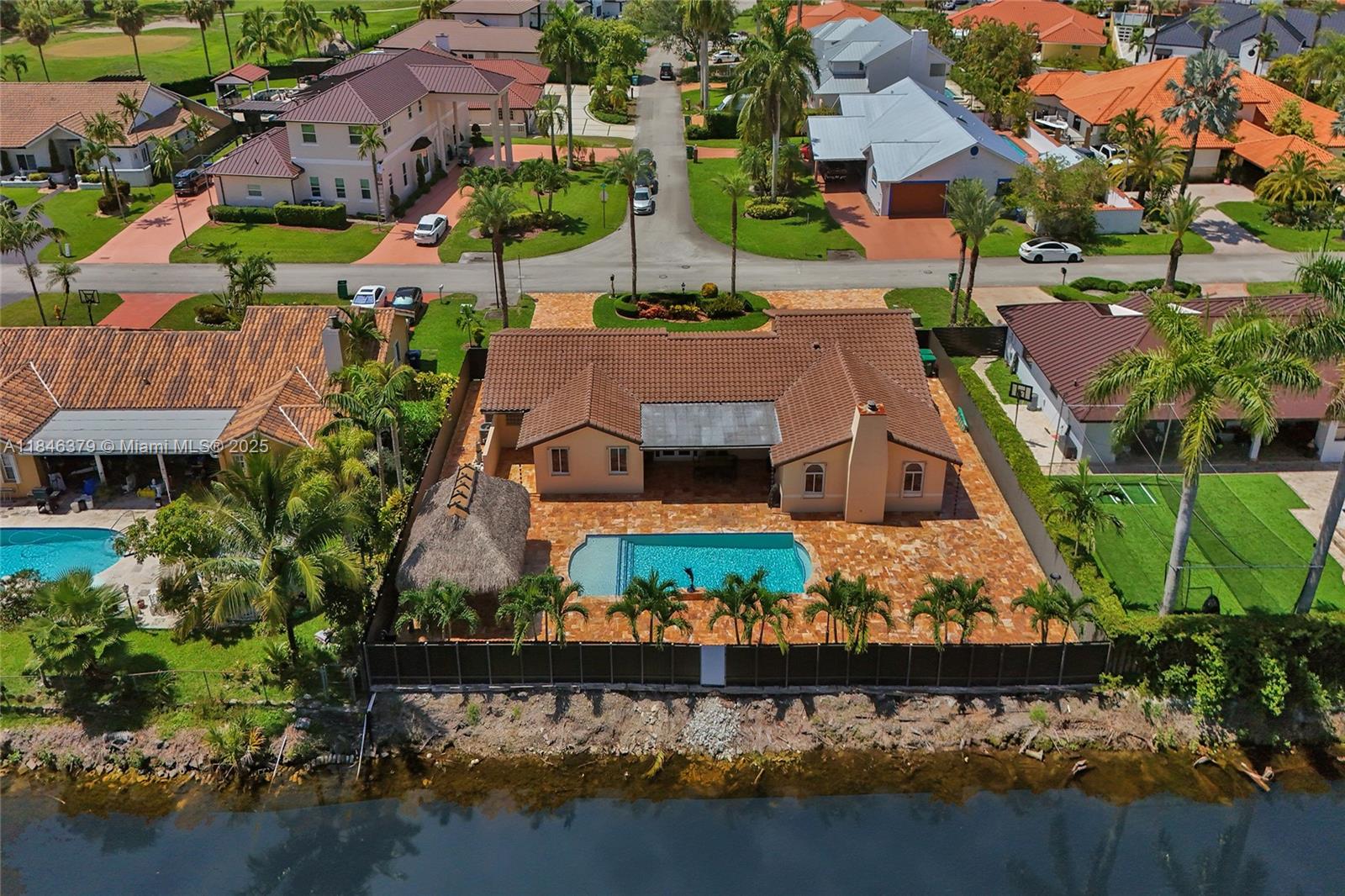 You have found the place you will call home in this 4/3 single family home perfect for entertaining family & friends at BBQs & holidays in the large size backyard w/ a covered terrace plus a tiki hut equipped w/ surround sound, TV, fans & adjacent to the saltwater pool for those hot summer days. Own a jet ski or small boat? There is room for them as well. The property also features accordion shutters, approx. 3 yr. old roof w/ 10 yr. warranty, two A/C units approx. 4 yrs. old, tankless water heater, water softener/filter system, porcelain flooring throughout, wood kitchen cabinets, stainless steel appliances, circular driveway w/ recently installed pavers that accommodates several vehicles, camara system included in the sale & so much more. See it ... love it ... make it your own!