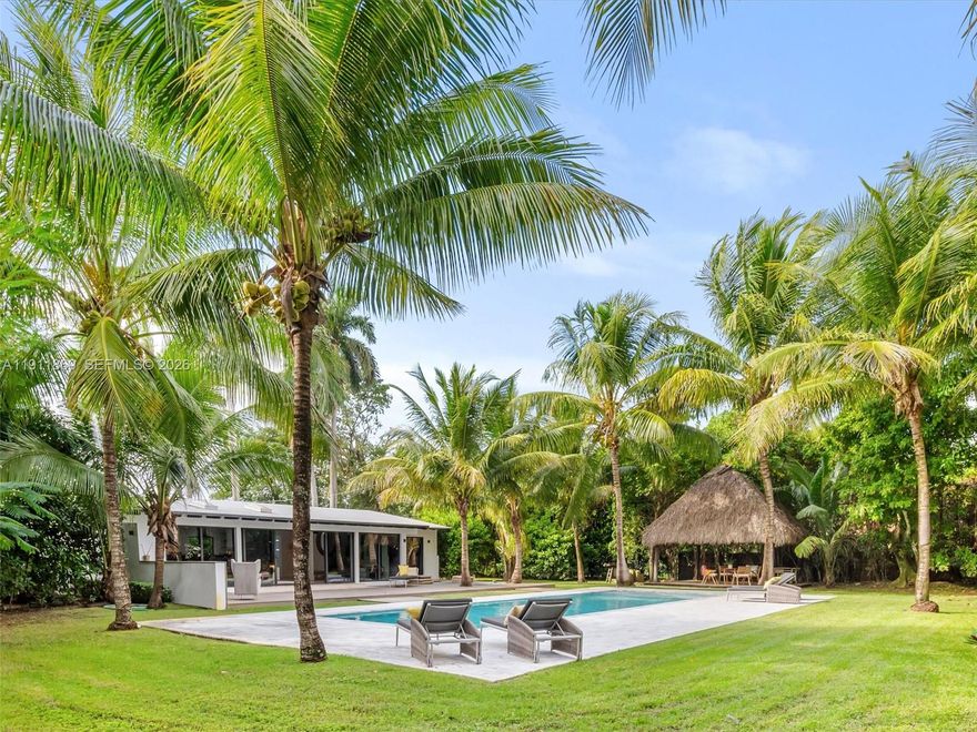 Enter this quiet, tropical retreat with the calming feel of Southeast Asia.  Fully Renovated in 2018 this 3 BD/3BA home sits on a 19,600 SF double lot with towering coco palms.  Inside, solid oak floors and marble baths ground the home with simple & beautiful materials.  The chef’s kitchen opens to a glass-lined living area with views of the  garden & pool. The modern home has impact doors & windows, a new roof, and sky lights.  A wide deck offers space for meditation or lounging. The tiki hut creates an easy outdoor living area, perfect for relaxing in the shade, reading, or dining. The large salt water pool completes the outdoor sanctuary. The entire setting feels blessed and transportive.  Located in El Portal, where streets are lined w mature shade trees and time moves a little slower.