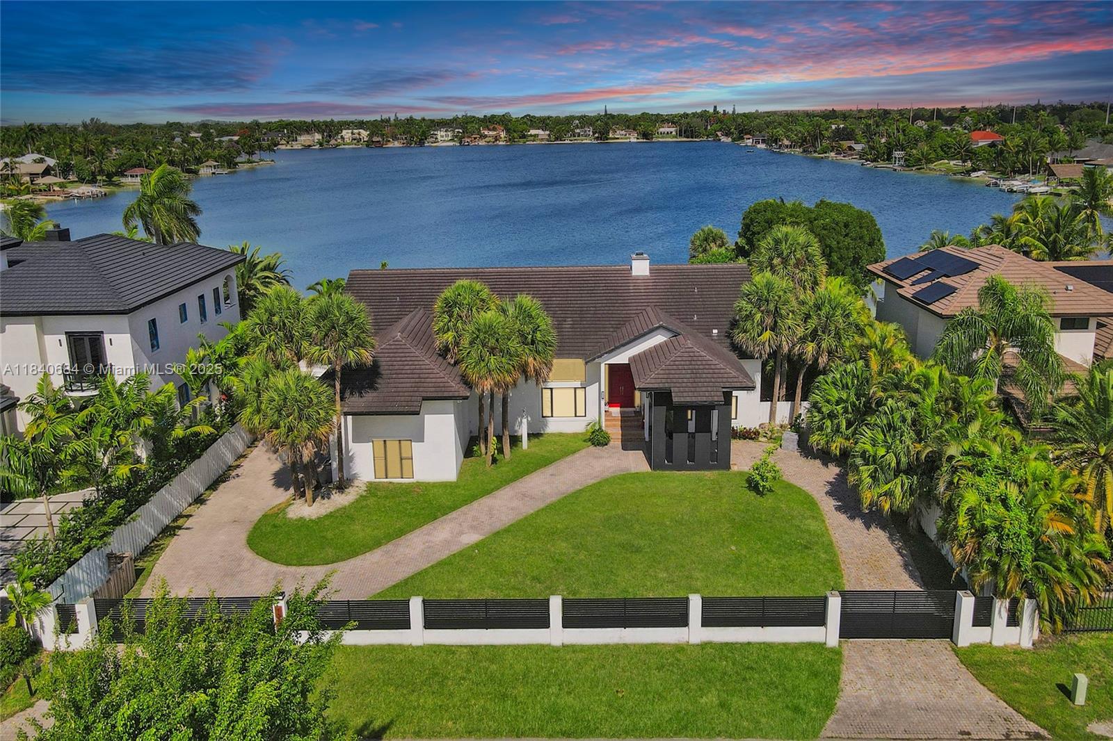 This isn't just a home; it's an expansive retreat on E-Lake, one of Miami's only operable lakes. Water sports, such as jet skiing, skiing, sailing, and kayaking, are all permitted on the lake. With a sprawling square foot of living space, this home provides an abundance of room to live, entertain, and relax. The first floor gleams with updated cabinets and marble floors, while the second floor offers the warmth of bamboo hardwood. The chef's kitchen is a true highlight, featuring upgraded Miele, Sub-Zero, and Wolf appliances, along with compact quartz countertops. Beyond the ample interiors, your private oasis awaits, featuring a private beach, a relaxing lanai, and a luxurious Jacuzzi, just a short walk from The Falls shopping center—a true one-of-a-kind must-see to appreciate.