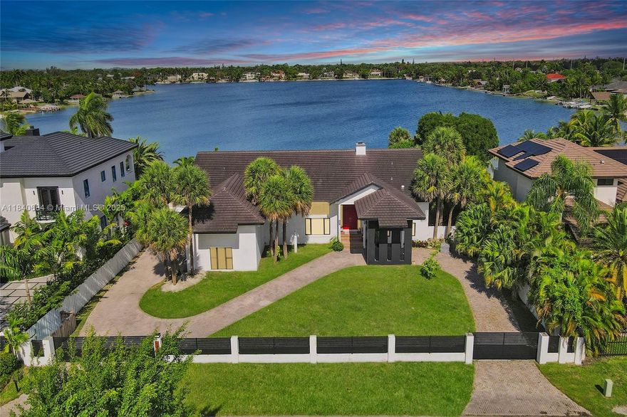 This isn't just a home; it's an expansive retreat on E-Lake, one of Miami's only operable lakes. Water sports, such as jet skiing, skiing, sailing, and kayaking, are all permitted on the lake.  With a sprawling square foot of living space, this home provides an abundance of room to live, entertain, and relax. The first floor gleams with updated cabinets and marble floors, while the second floor offers the warmth of bamboo hardwood. The chef's kitchen is a true highlight, featuring upgraded Miele, Sub-Zero, and Wolf appliances, along with compact quartz countertops. Beyond the ample interiors, your private oasis awaits, featuring a private beach, a relaxing lanai, and a luxurious Jacuzzi, just a short walk from The Falls shopping center—a true one-of-a-kind must-see to appreciate.