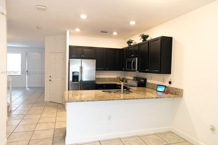 Modern 3-Bedroom Townhouse in Aquabella. Gated community offers top-notch amenities. Explore this contemporary-style townhouse with nearly 1,959 sq. ft. of living space, located in the vibrant Aquabella community in Hialeah. This 3-bedroom, 3-bath home features an open kitchen with upgraded granite countertops, quality wood cabinets, stainless steel appliances, and ample storage space. The first floor is tiled, while the upper level boasts brand new laminate flooring. The spacious living room is separate from the dining and family areas, and the huge master bedroom includes a large walk-in closet. Enjoy the convenience of a dedicated laundry room and an attached garage, with a covered parking spot and additional driveway space. The patio features low-maintenance artificial grass.